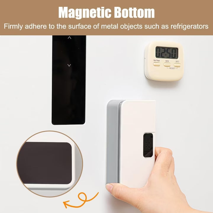 Hand holding a small electronic device with a magnetic bottom, shown adhering to a refrigerator.